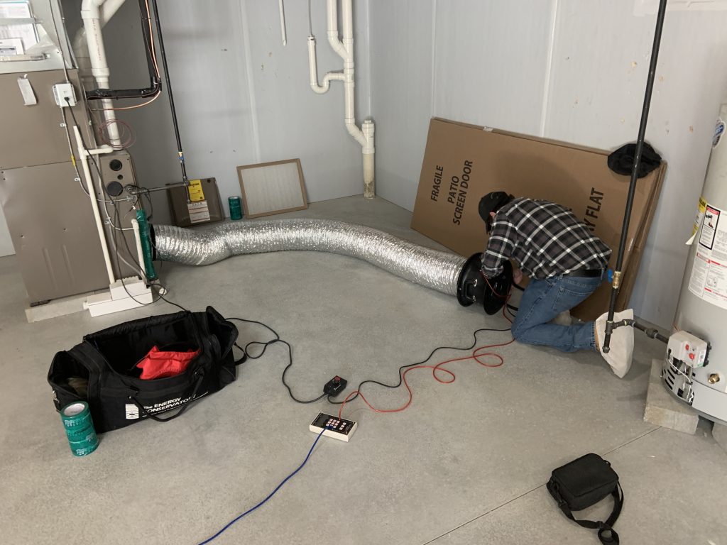 HERS Rater performing duct leakage testing on a home.