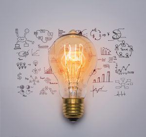 Image of a lightbulb in front of business strategy drawing