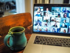 Photo of a laptop with virtual conference attendees shown in a grid.